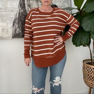 Rust color tunic sweatshirt with thumb holes.